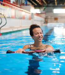 Black woman attending water aerobics class in a swimming pool