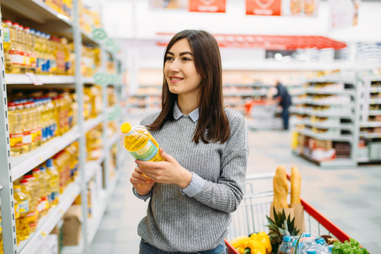 Woman choosing sunflower oil in a supermarket