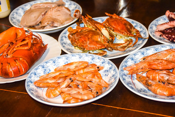 many different seafood lobster shrimp octopus crabs dish lie on meze plates