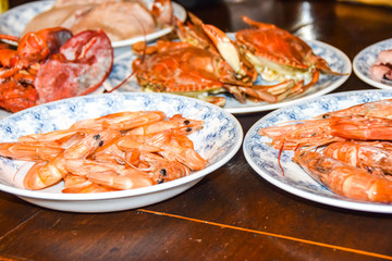 many different seafood lobster shrimp octopus crabs dish lie on meze plates