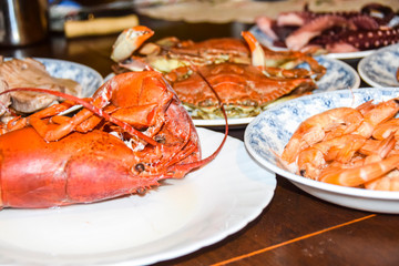 many different seafood lobster shrimp octopus crabs dish lie on meze plates