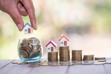 Real estate investment. House and coins on table.
