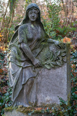 Statue einer trauernden Frau aus Stein gemeißelt als Grabstein auf dem Friedhof in Berlin Frohnau ...