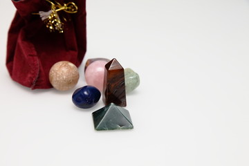 Magical stones and crystal of different shapes and colors lying in bulk on a white background.
