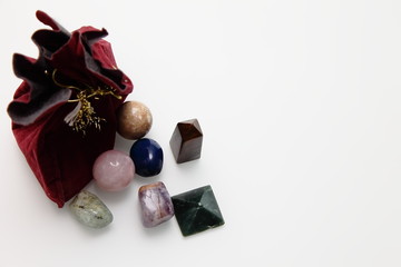 Magical stones and crystal of different shapes and colors lying in bulk on a white background.