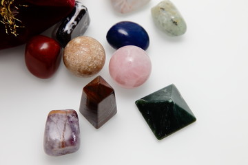 Magical stones and crystal of different shapes and colors lying in bulk on a white background.