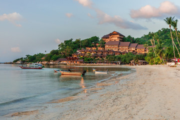 Fototapeta na wymiar Romantic sunset on a tropical island with white sand beach at a luxury resort