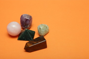 Magical stones and crystals of various shapes and colors lying loose on a yellow background