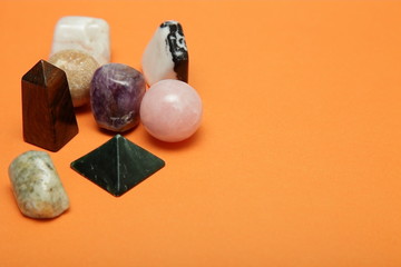 Magical stones and crystals of various shapes and colors lying loose on a yellow background