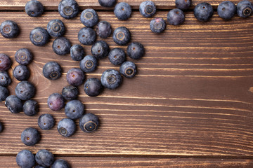 Lot of whole fresh sweet purple blueberry american flatlay on brown wood