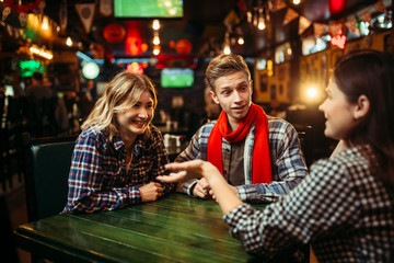 Teenagers sitting at the table in sports bar