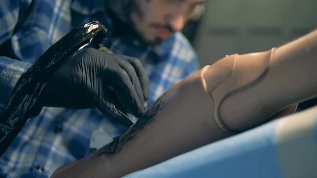 A man drawing a tattoo on an artificial arm, bionic prosthesis.