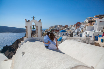 Fototapeta na wymiar young couple honeymoon on the most romantic island Santorini, Greece