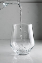 water is poured into a glass from a decanter