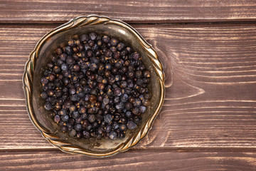 Lot of whole dry juniper berry seed flatlay on brown wood