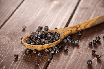 Lot of whole dry juniper berry seed on brown wood