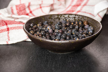 Lot of whole dry juniper berry seed on grey stone