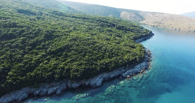 Aerial footage capturing a panoramic scene of the mediterranean coastline with crystal clear blue water. 4k drone video panning from right to left.