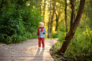 Fototapeta premium Little boy playing during stroll in the forest