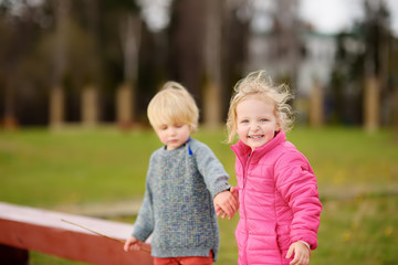 Fototapeta na wymiar Portrait of little boy and girl playing on kindergarten back yard