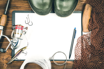Fishing gear - fishing, fishing, hooks and baits, an old sheet of paper on a wooden background....