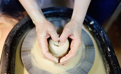Fototapeta premium Close-up photo of hands of woman making clay object