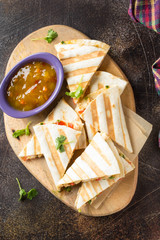 Mexican quesadilla with chicken, tomatoes, cheese and grilled sauce. Tasty snack in a pellet, healthy food