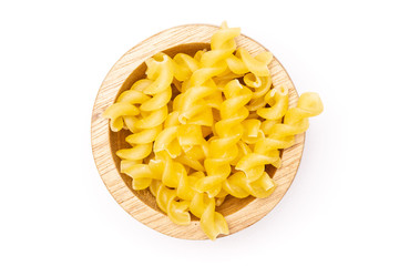 Lot of pieces of raw italitan yellow pasta torti with wooden bowl flatlay isolated on white background