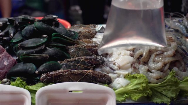 Сounter with varied seafood at the Thai market.