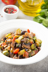 Vegetable stew with eggplant, zucchini, tomatoes, onions, mushrooms, garlic and cilantro. Vegetarian ajapsandali, Italian caponata. Traditional saute Ratatouille