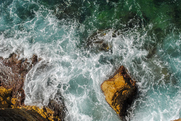 Sea waves splashing at the rocks green lush nature surrounding the beautiful sea water in a...