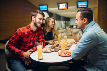 Friends in bowling club, game board on background