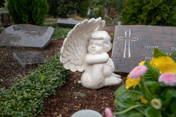 Schöner Engel vor einem Grabstein 