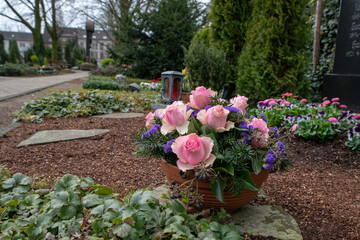 Rosenstrauß vor einer Grablampe 