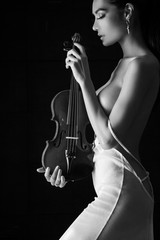 The sexy woman wearing white dress,holding violin in hand,beauty naked body shape posing,black and...