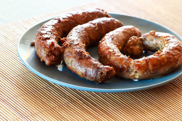 delicious juicy grilled sausages on a plate on the table