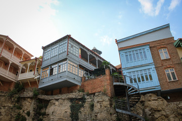 Houses hanging over the cliff. The capital of Georgia is Tbilisi. Old city. Beautiful house, low buildings. City architecture. House on a pole