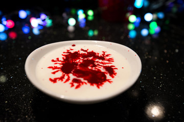 Woman is cooking in kitchen, baking a red velvet cake. Using red food coloring in milk for dough....