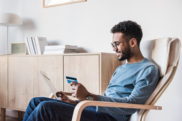 Young man using digital tablet with credit card. Businessman or entrepreneur working. Online shopping, e-commerce, internet banking, spending money, enjoying life concepts