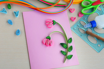 Obraz na płótnie Canvas Quilling technique. Making decorations or greeting card. Paper strips, flower, scissors. Handmade crafts on holiday: Birthday, Mother's or Father's Day, March 8, Wedding. Children's DIY concept.