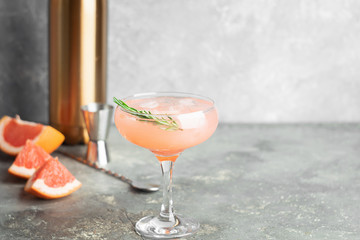 Refreshing summer cocktail grapefruit champagne rosemary juice in glass goblets on a light gray concrete background.