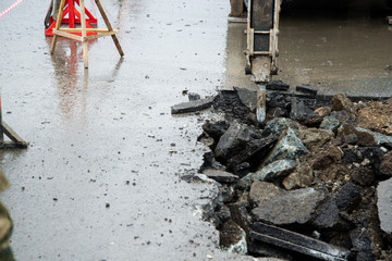 Repair of communications located under the carriageway. Road repair car breaks asphalt.