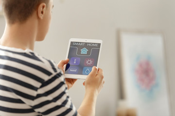 Teenage boy using application of smart home automation