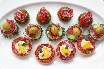Tasty canapes on plate, closeup