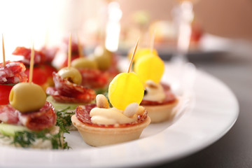 Tasty canapes on plate, closeup