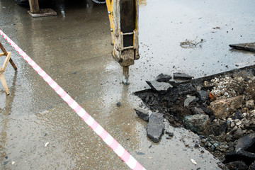 Repair of communications located under the carriageway. Road repair car breaks asphalt.