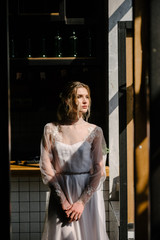 Bride in white wedding dress posing indoors