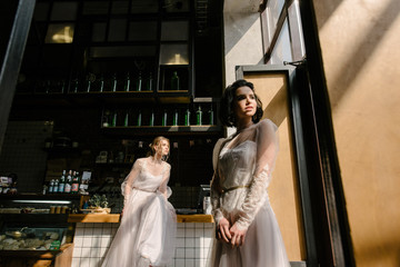 Girls in white wedding dresses are posing. Advertising of wedding dresses