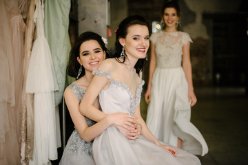 Girls in white wedding dresses are posing. Advertising of wedding dresses