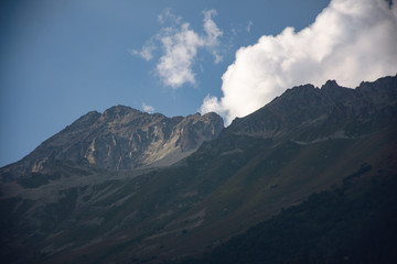 Large panorama Massive Caucasian mountains in the surroundings of dombai in the clouds. Summer day.
